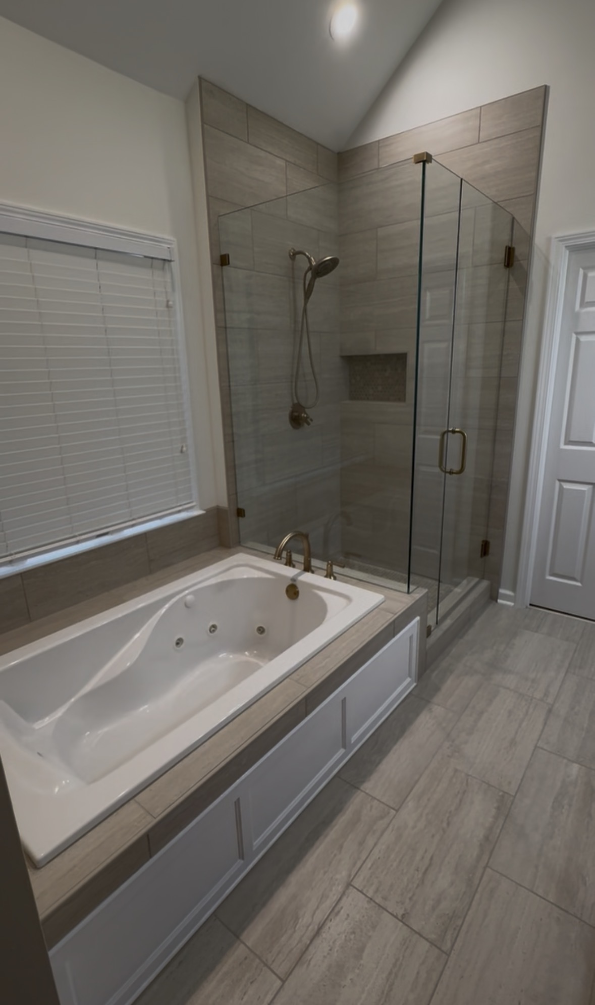 Primary bath with tiled glass shower and tub